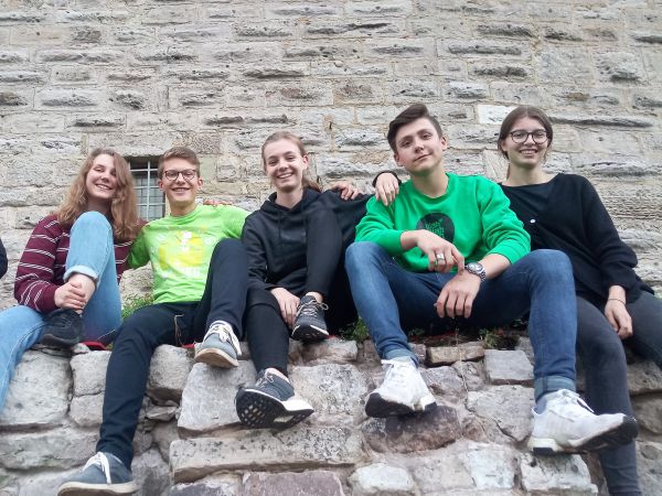 Jugendliche sitzen auf einer Mauer