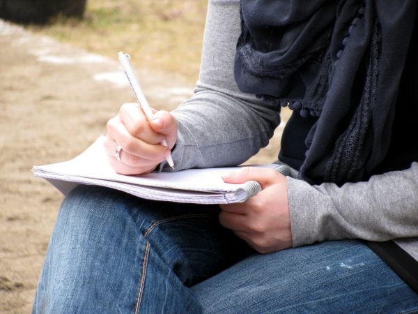 Schreibblock auf Knien