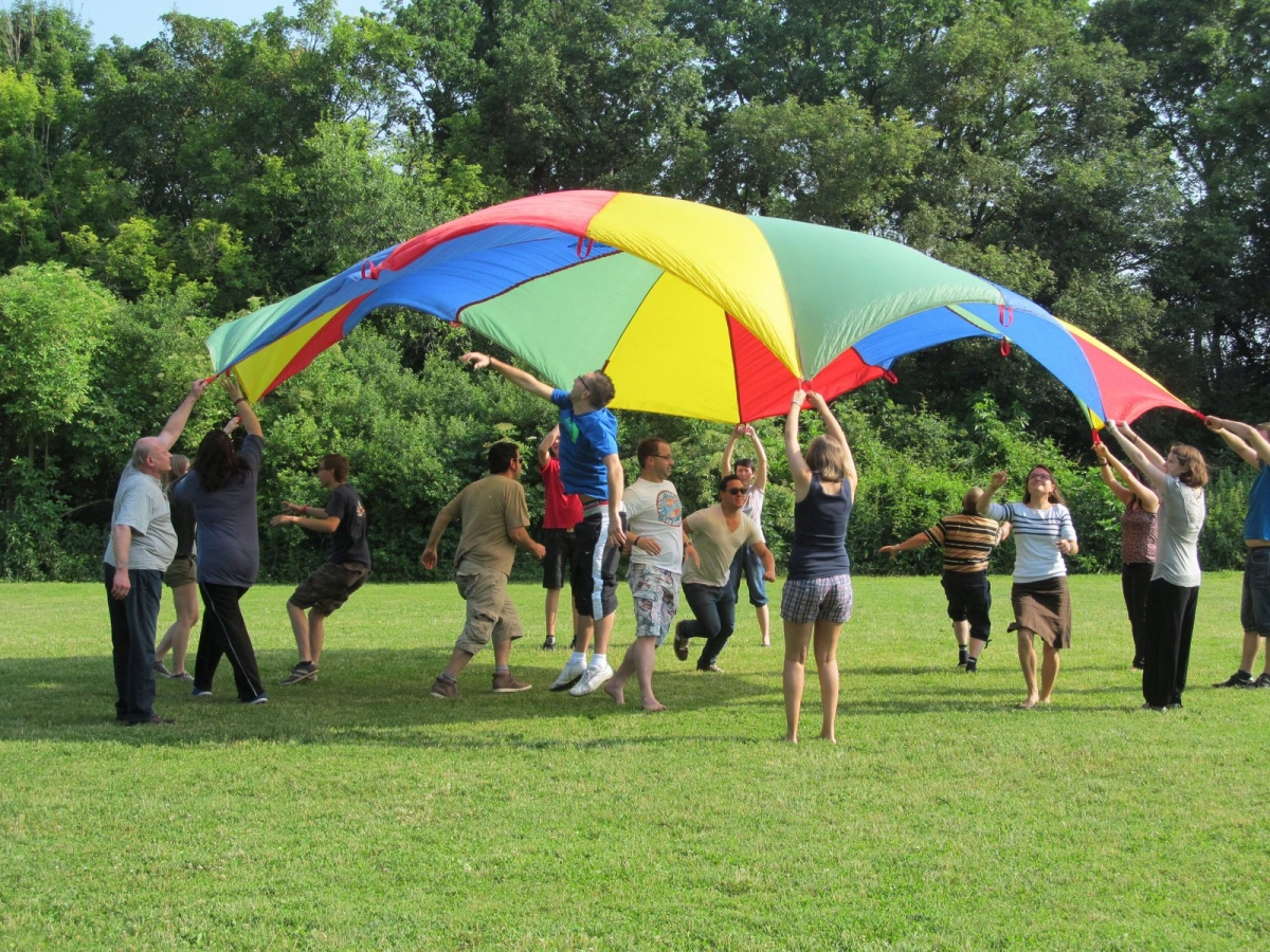 Gruppe spielt mit Fallschirm im Freien