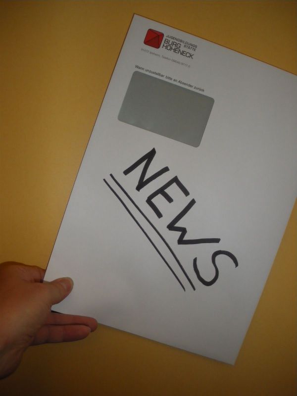 Hand hält Briefumschlag mit der Aufschrift News ins Bild