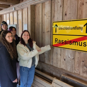 Menschengruppe  vor Verkehrsschild