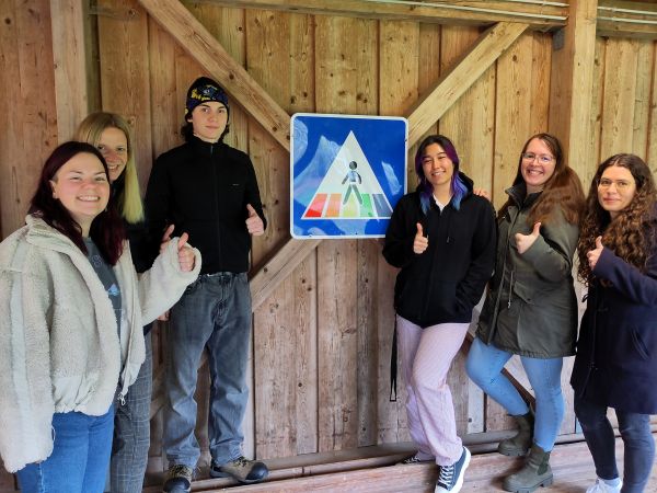 Menschengruppe vor Verkehrsschild